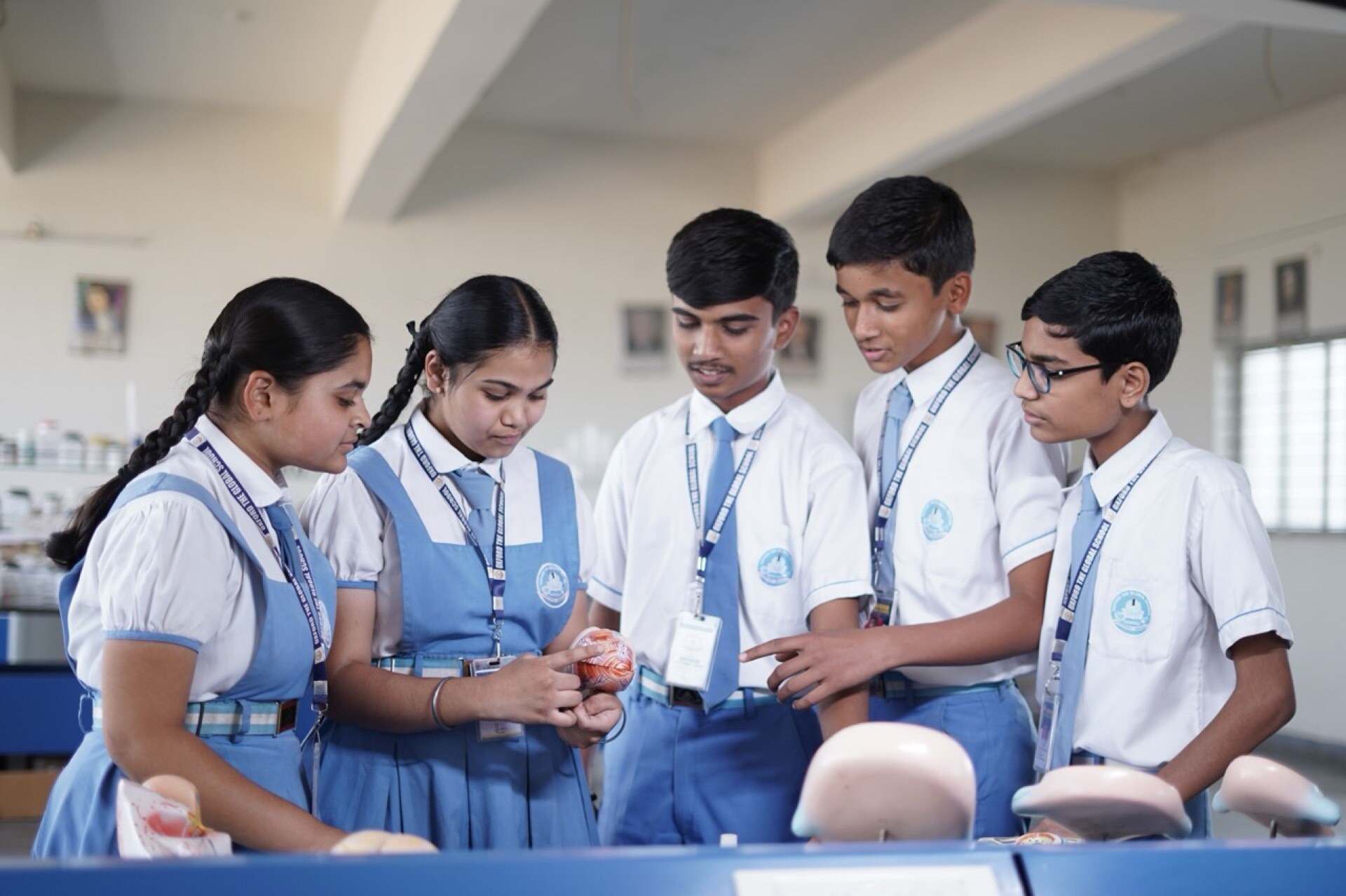 Students gathered around an anatomy model during a science lesson