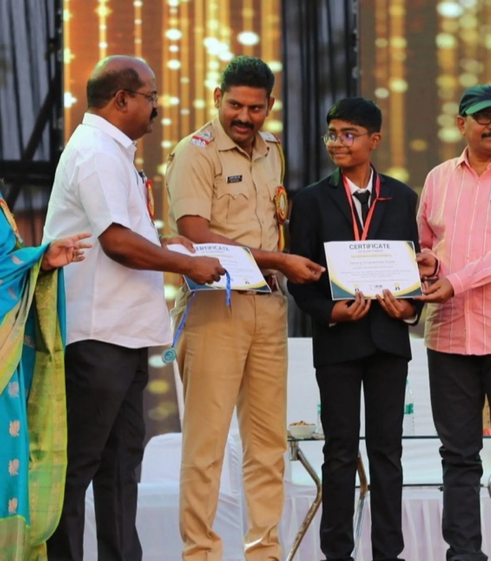 A student receiving a certificate from guests on stage