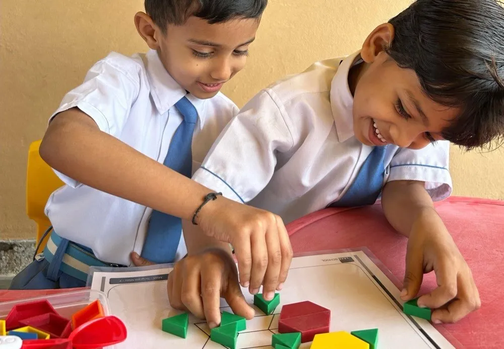 Two young students absorbed in a hands-on shape activity