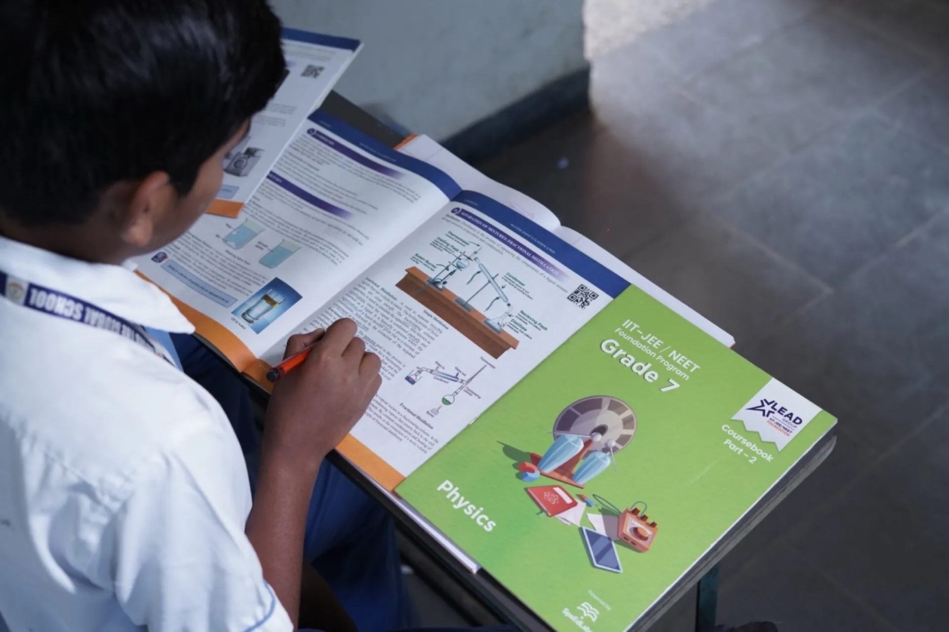 A student reading a science textbook at his desk