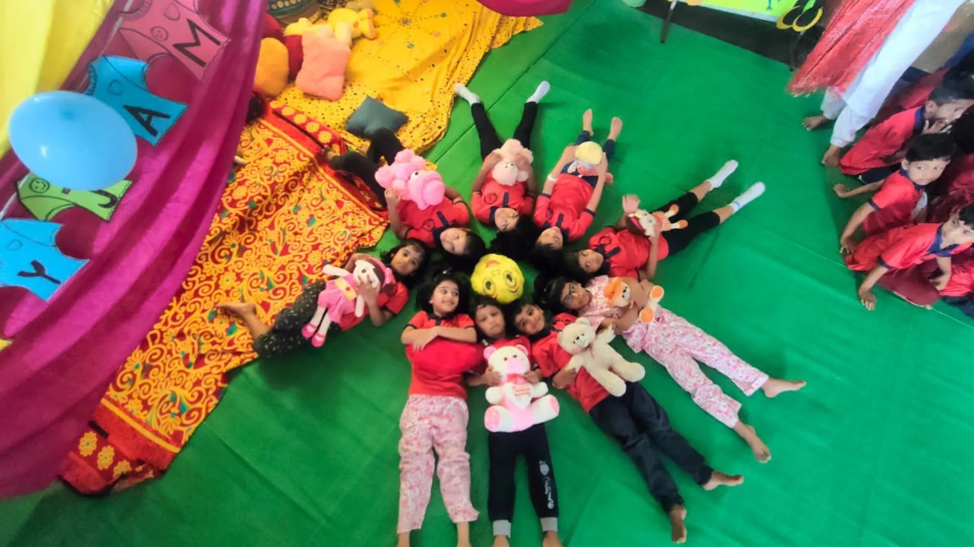 Children lying in a circle with their heads together during a camp game